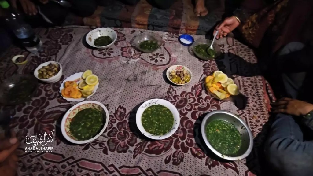 A tablecloth is spread with bowls of soupy grass and a few plates of lemon slices